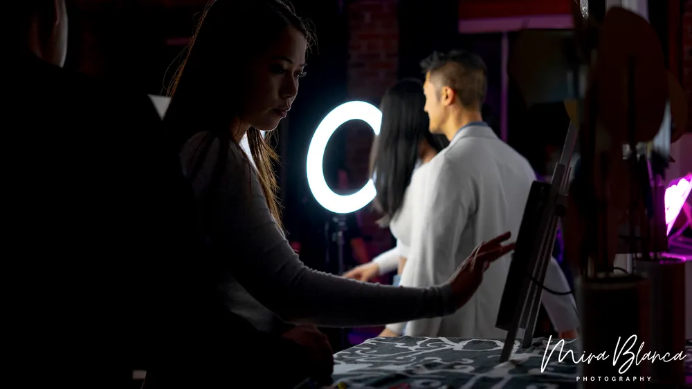 Mira Blanca Photo Booth in use beside an illuminated ring light